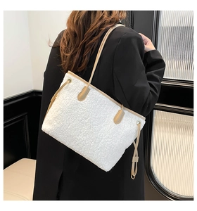 Detail of white sherpa tote bag with khaki leather straps and reinforced stitching