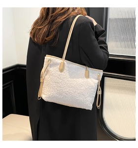 Detail of white plush tote bag with light beige leather straps over a black coat