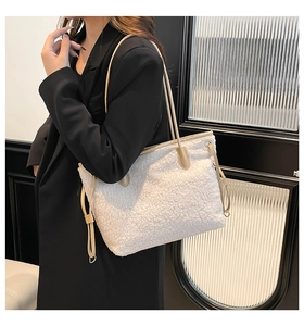 Detail of soft cream faux shearling tote bag with side drawstring and slim shoulder straps