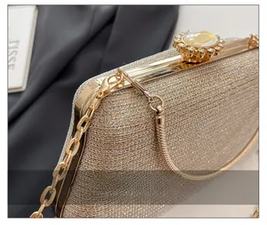 Macro shot of gold metal frame and amber jewel clasp on champagne glitter evening clutch