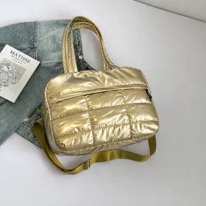 Detalle del bolso tote acolchado en color dorado metálico con correa ajustable al hombro