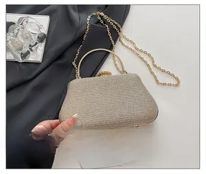 Detail of gold glitter evening bag featuring a round metal handle and rhinestone clasp