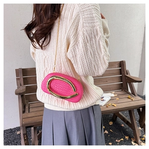Detail of fuchsia woven leather clutch bag with elegant gold buckle and chain strap
