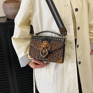 Chic leopard print handbag with golden lion head buckle and studded black flap cover