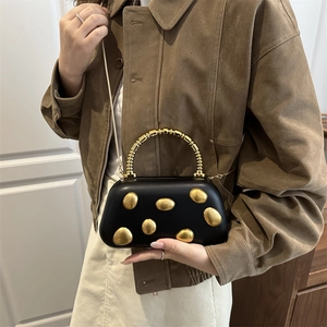 Schicke schwarze Abendtasche mit goldenen Metallic-Kieseln und Kugelgriff