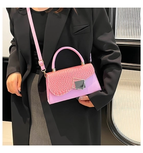 Model wearing a pink faux crocodile texture small crossbody bag with silver buckle detail