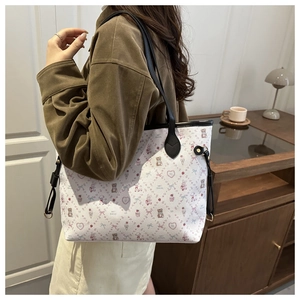 Sac cabas blanc avec motifs de dessins animés et fines bretelles noires sur un mannequin