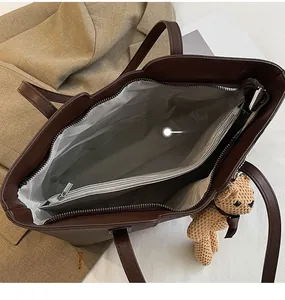 Internal structure of dark brown tote bag with zipper pocket and fabric lining