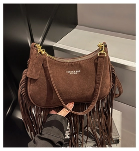 Detail of dark brown suede handbag featuring long fringe and vintage gold hardware