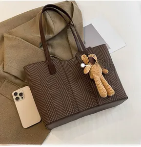 Brown herringbone woven tote bag size comparison with an iPhone showing spacious capacity