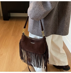 Detail of vintage brown suede crescent bag with long fringe and gold metal zipper