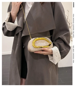 Detail of evening clutch featuring champagne rhinestones and U-shaped gold handle