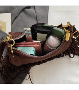 Detail of bohemian suede crossbody bag showing spacious interior for phone and cosmetics