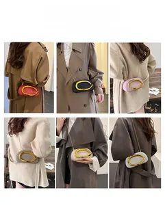 Close-up of stylish chain bags featuring a large gold metal U-shaped buckle decoration