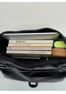 Spacious interior of a black quilted tote bag showing capacity for laptop and books