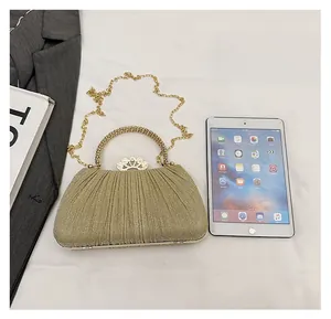 Size comparison of the gold glitter clutch bag with crown clasp and chain strap