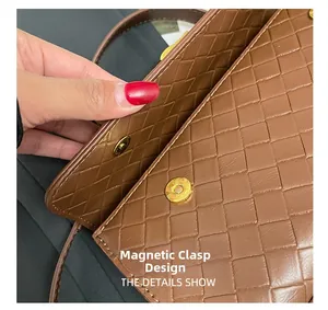 Dettaglio della trama in pelle intrecciata marrone e chiusura magnetica dorata della borsa