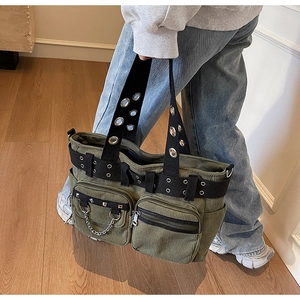 Detail of dark green corduroy tote bag with punk rivets, metal chains and large pockets