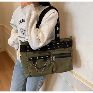 Detail of army green corduroy tote bag with punk rivets and metal chain elements