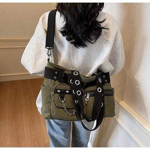 Detail view of army green corduroy tote bag with punk rivets and metal chain on a model