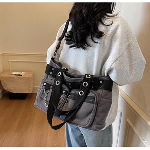 Detail of dark grey corduroy tote bag with punk rivets, metal eyelets and multi-pockets