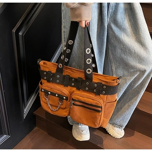 Detail of brown corduroy tote bag featuring punk rivets and metal chain decorations
