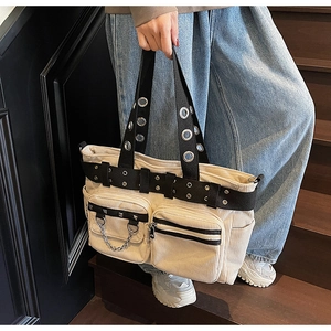 Detail of off-white corduroy tote with metal rivets and black buckled straps
