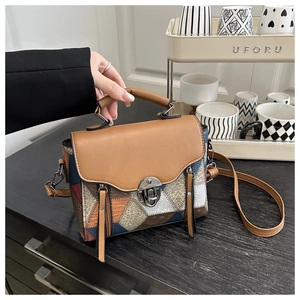 Dettaglio borsa a mano patchwork con chiusura in metallo e tracolla marrone