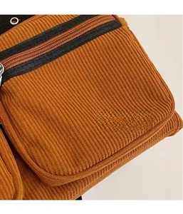 Close-up of caramel corduroy fabric with black zipper and vintage ribbed texture detail