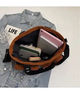 Macro view of spacious interior of brown corduroy tote bag holding tablet and notebook