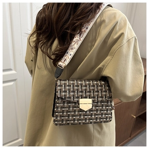 Close-up of vintage plaid crossbody bag with wide floral strap and gold lock detail