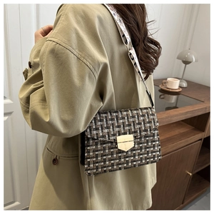 Detail of tweed crossbody bag with gold lock and wide embroidered shoulder strap