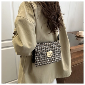 Detail of retro plaid crossbody bag with gold buckle on trench coat model