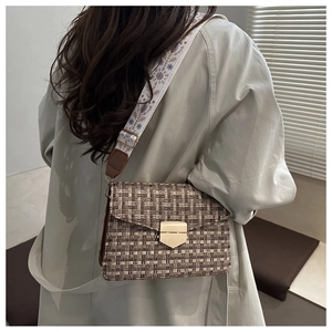 Detail of retro tweed crossbody bag with embroidered wide strap and golden clasp lock