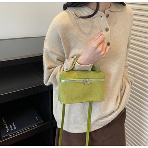 Détail du sac boîte en daim vert avec fermeture éclair en cœur et texture micro polaire