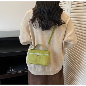 Detail of green mini box bag showing heart zippers and suede-like matte finish