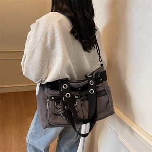 Grey corduroy punk tote bag with rivet details and metal chains shown in a casual wear style