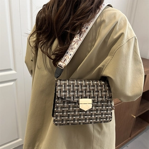 Retro plaid crossbody bag with wide embroidered strap and gold shield lock on a model