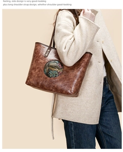 Detail view of ethnic elephant embossed tote bag in dark brown with metal hardware