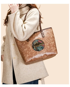 Detailed view of vintage embossed tote bag with ethnic pattern and leather texture