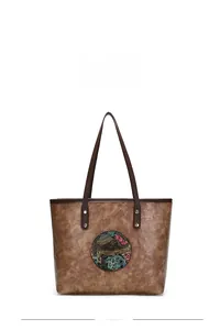 Detail of vintage brown leather tote bag with circular elephant floral embossing