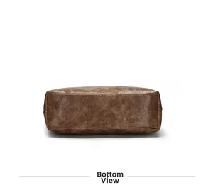 Detailed view of the rectangular leather base and stitching of the brown tote bag