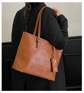 Gros plan du cabas gaufré cœur caramel avec sa mini pochette et ses finitions dorées