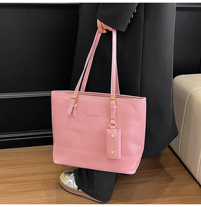 Détail du sac cabas rose à gaufrage cœur avec ferrures dorées et petite pochette