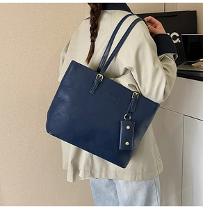 Détail du cabas bleu marine avec motifs de cœurs gaufrés et mini pochette suspendue