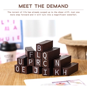 Macro shot of vintage wooden alphabet stamps featuring white uppercase capital letters