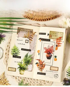 Detailed view of vintage botanical PET stickers with fern and maple leaf motifs on desk