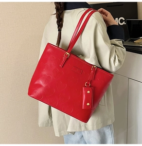 Détail du sac cabas rouge avec motif cœur gaufré et petite pochette assortie amovible