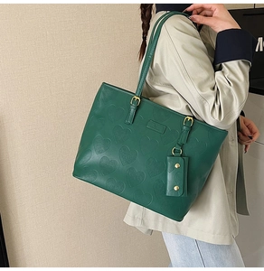 Détail du sac cabas vert foncé avec motif gaufré en cœur et boucle dorée réglable