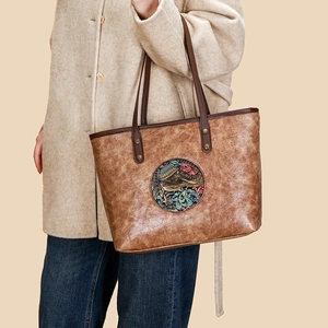 Vintage brown leather tote bag with elephant embossed pattern shown on a model